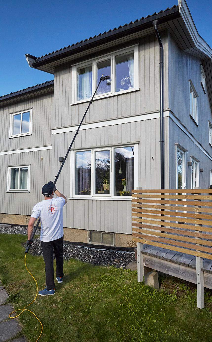 en mann som vasker de ytre vinduene i et hus