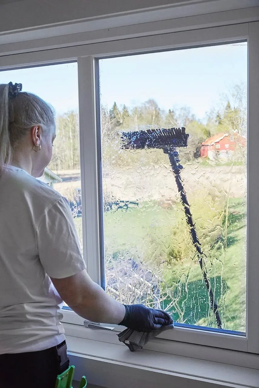 en mann som vasker de ytre vinduene i et hus